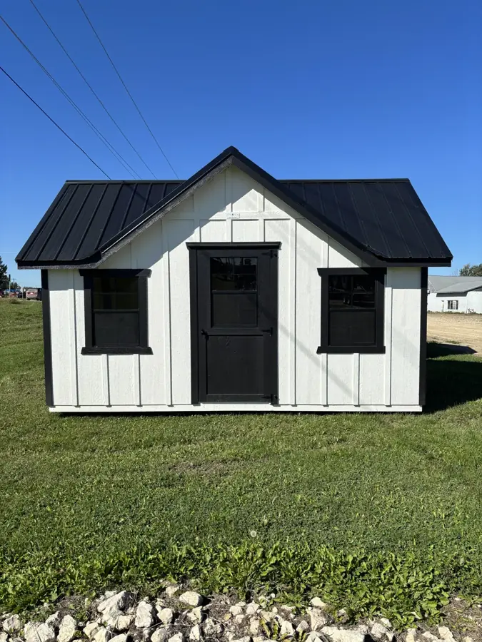 White classic shed with a black metal roof, two windows and a black door